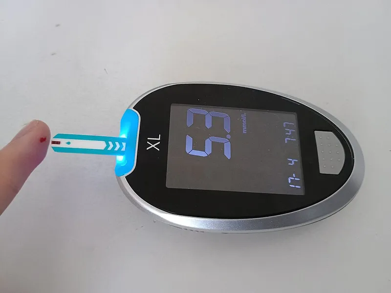 Blood glucose meter showing a reading after a finger-prick test — checking for high blood sugar symptoms